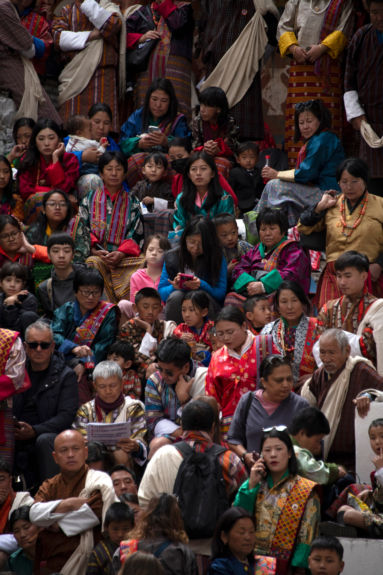 Bhutanese families and visitors gathered in traditional dress at a tshechu festival
